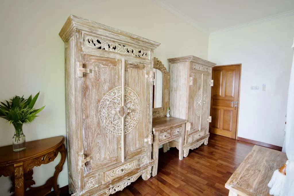 Hand-carved wooden armoire and console in a guest room