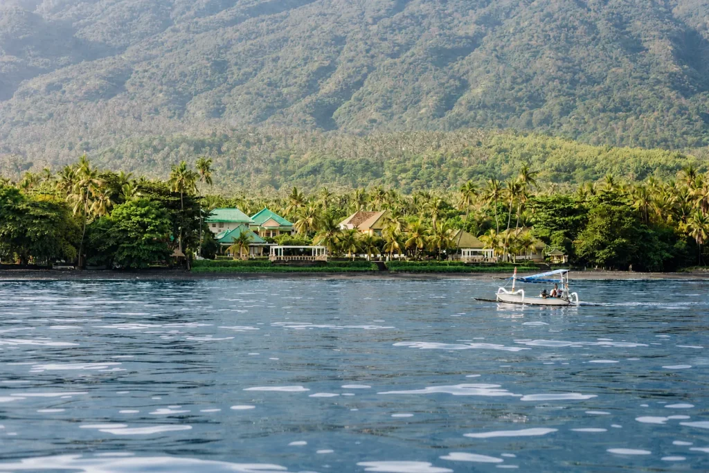 The resort seen from the water, backed by the north Bali mountains