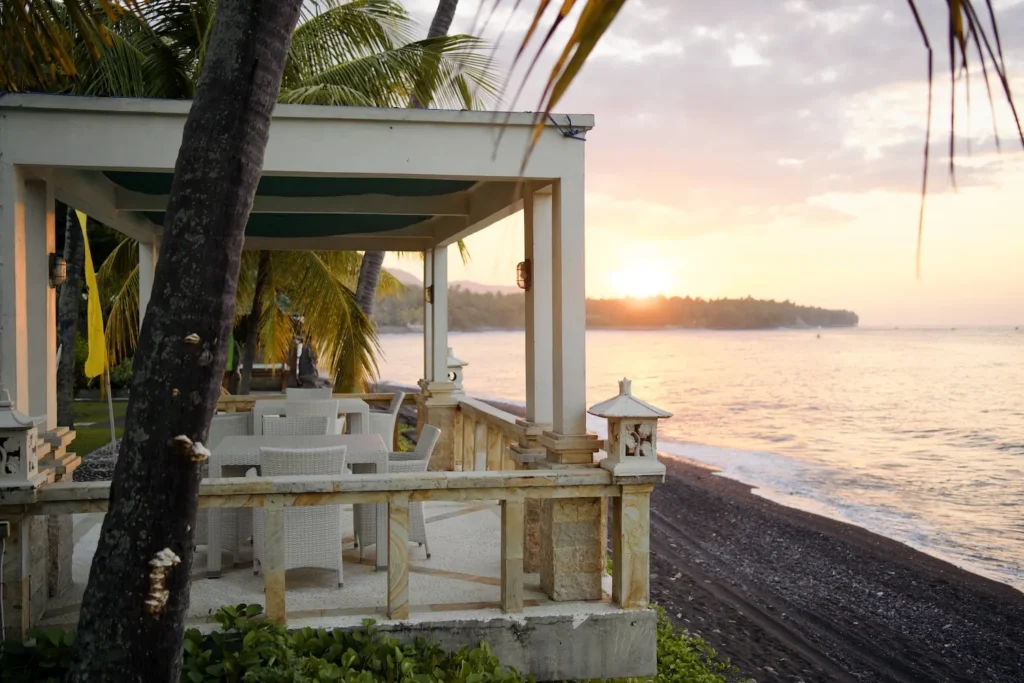 Seafront pavilion and loungers at sunset, with the beach in the foreground